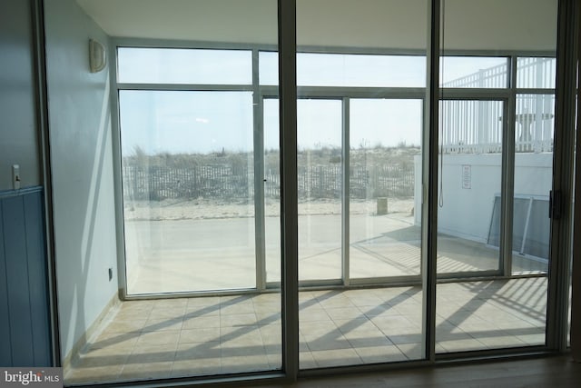 doorway to outside with a wall of windows and plenty of natural light