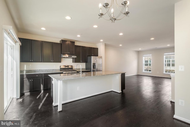 kitchen featuring dark hardwood / wood-style floors, pendant lighting, an island with sink, sink, and stainless steel appliances