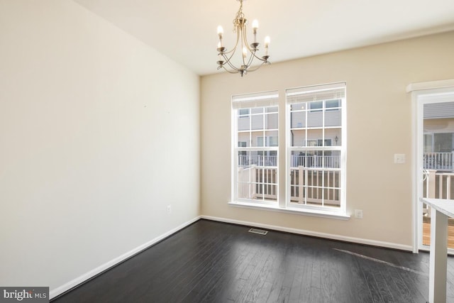 unfurnished dining area featuring dark hardwood / wood-style floors and a chandelier