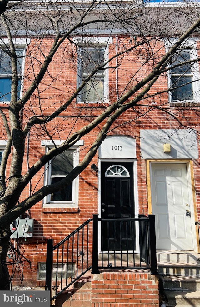 doorway to property featuring brick siding