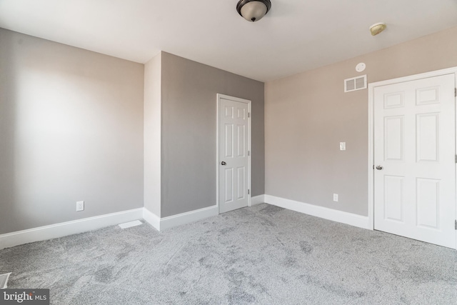 unfurnished room with baseboards, visible vents, and light colored carpet