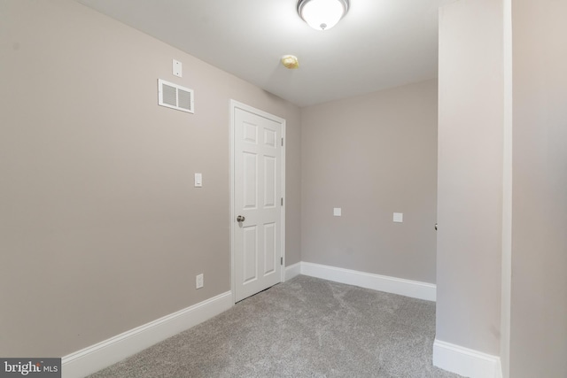 spare room with light carpet, baseboards, and visible vents