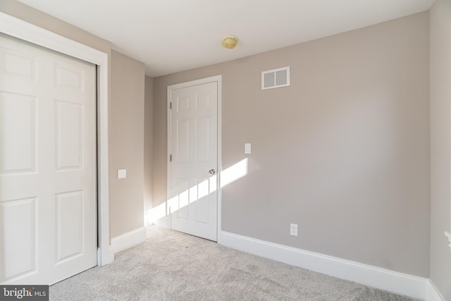 unfurnished bedroom with baseboards, visible vents, and light colored carpet