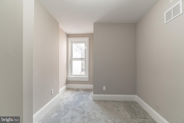 empty room featuring visible vents, light carpet, and baseboards