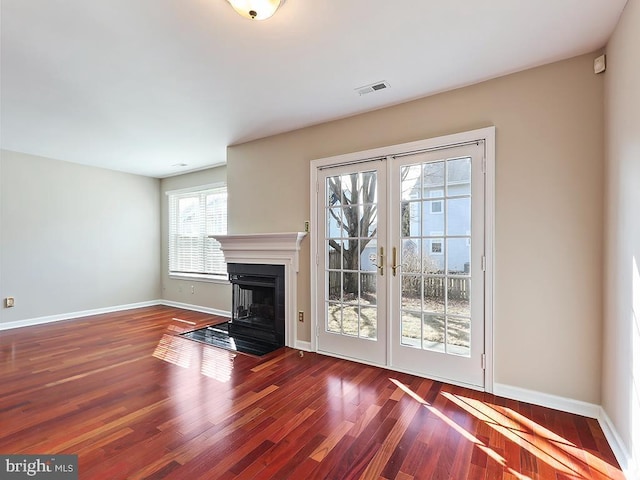 unfurnished living room featuring french doors and dark hardwood / wood-style flooring