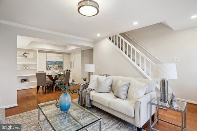 living room featuring wood-type flooring and ornamental molding