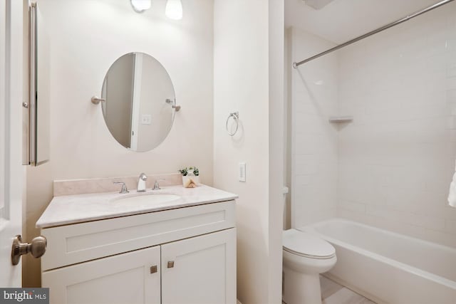 full bathroom featuring vanity, tiled shower / bath, and toilet