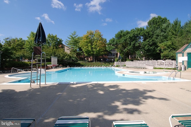 view of swimming pool with a jacuzzi and a patio area