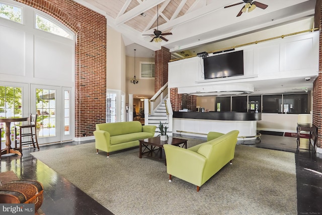 living room featuring high vaulted ceiling, wooden ceiling, beamed ceiling, ceiling fan, and brick wall