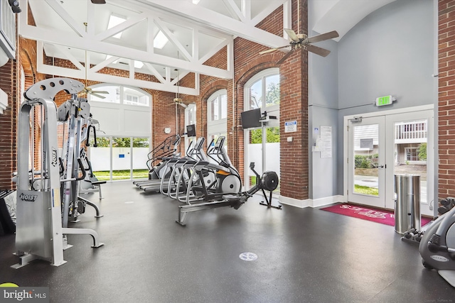 gym with french doors, ceiling fan, and brick wall