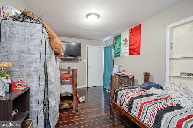 bedroom with dark hardwood / wood-style flooring