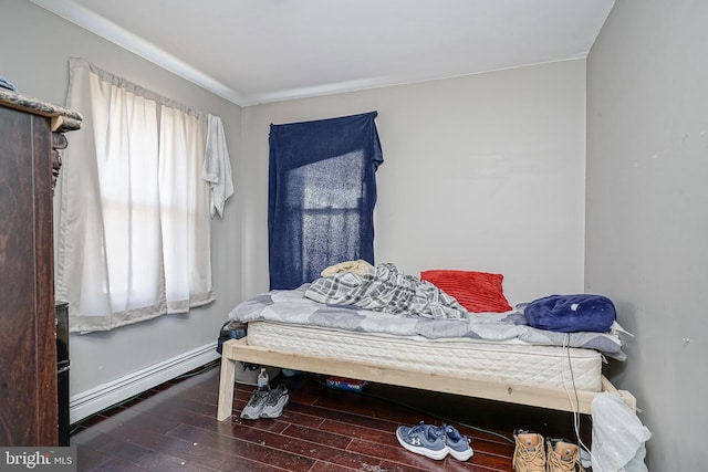 bedroom with hardwood / wood-style floors and baseboard heating