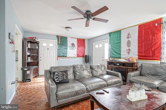 living room with dark parquet flooring and ceiling fan