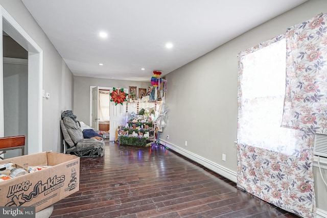 interior space with a baseboard heating unit and dark hardwood / wood-style flooring