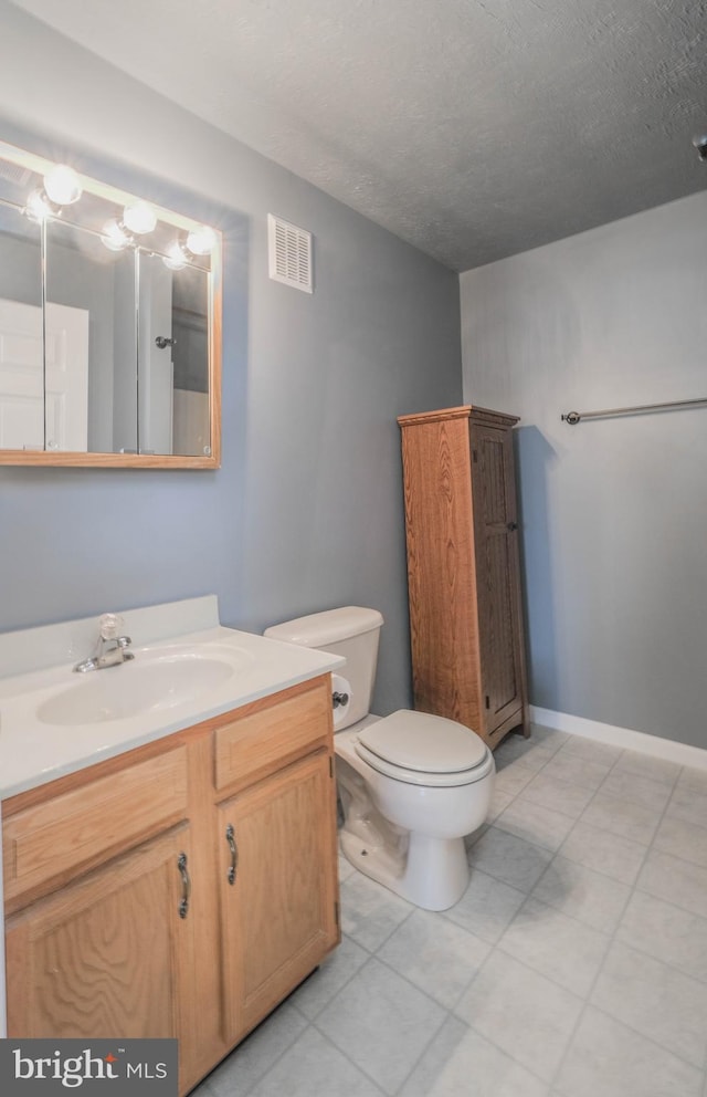 bathroom featuring vanity, toilet, and a textured ceiling