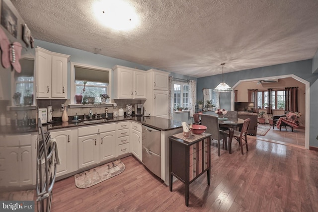 kitchen with white cabinetry, sink, decorative light fixtures, and hardwood / wood-style flooring