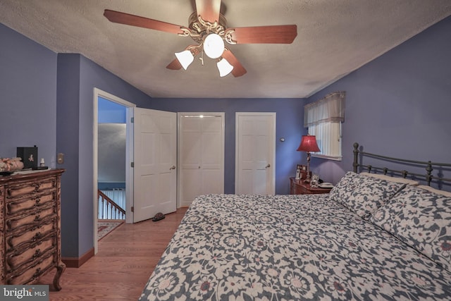 bedroom with ceiling fan, a textured ceiling, and light wood-type flooring