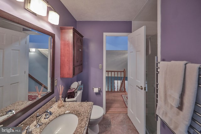 bathroom with an enclosed shower, vanity, and toilet