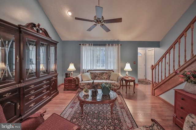 living room featuring ceiling fan, lofted ceiling, and light hardwood / wood-style floors