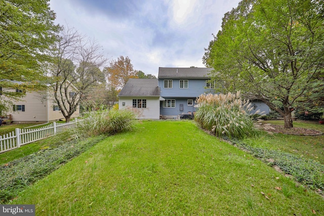 rear view of property featuring a lawn