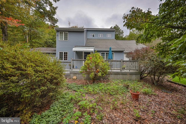 rear view of house featuring a wooden deck