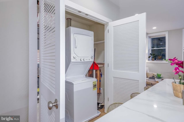 laundry room with stacked washing maching and dryer