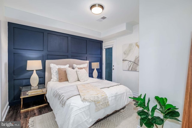 bedroom with dark hardwood / wood-style floors