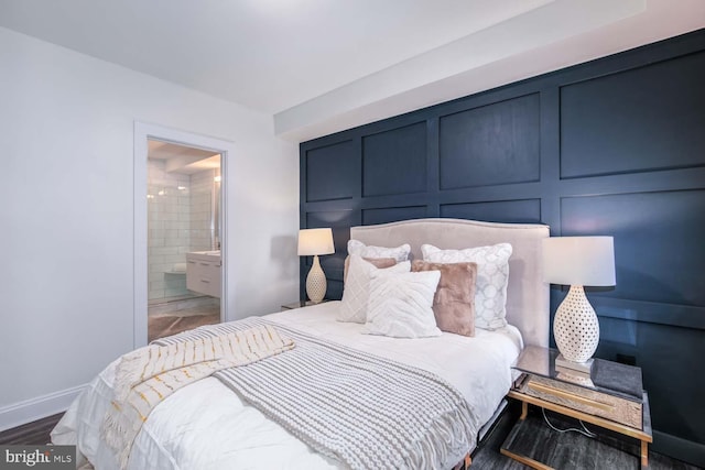 bedroom with dark hardwood / wood-style flooring and ensuite bath