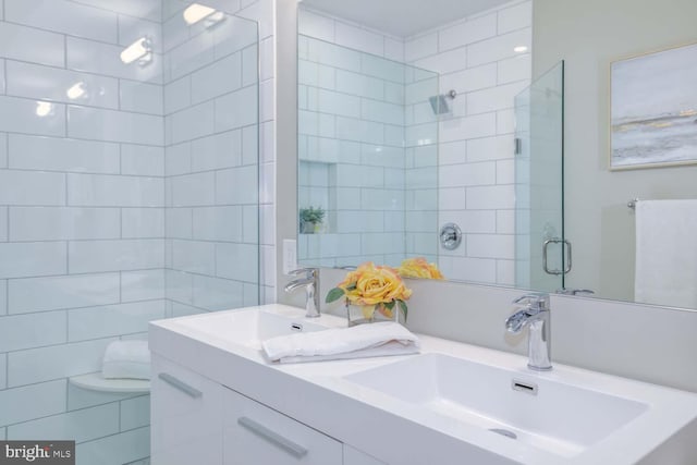 bathroom with vanity, tile walls, and walk in shower