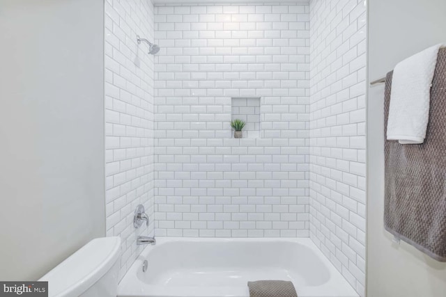 bathroom with tiled shower / bath and toilet