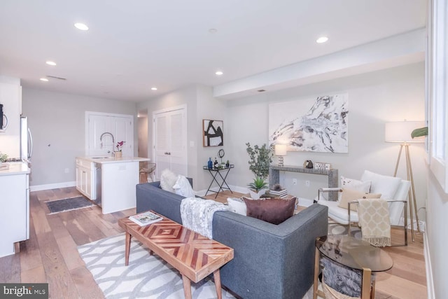 living room with sink and light hardwood / wood-style flooring