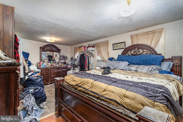 bedroom with a textured ceiling and cooling unit