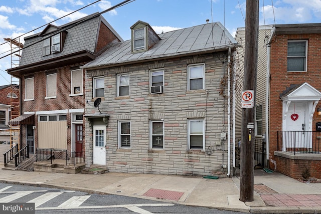 townhome / multi-family property with stone siding, metal roof, and a standing seam roof