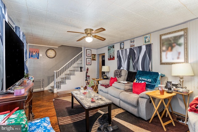 living room with dark wood-style floors, ceiling fan, and stairway