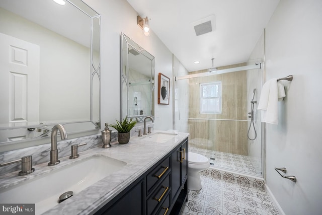 full bathroom with double vanity, a stall shower, toilet, and a sink