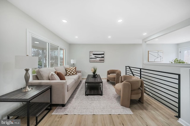 living room featuring light wood-type flooring, baseboards, and recessed lighting