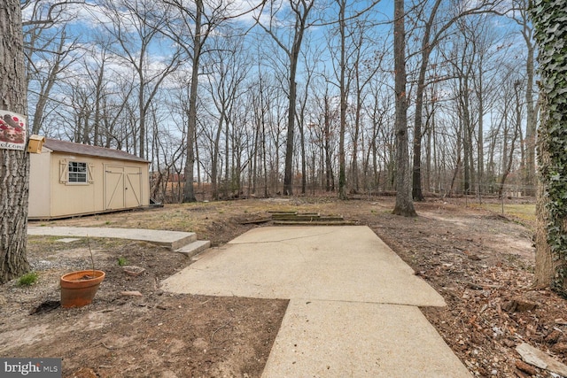 view of yard with an outdoor structure, a storage shed, and a patio