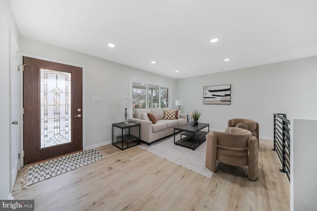 living area with light wood-style floors, baseboards, and recessed lighting