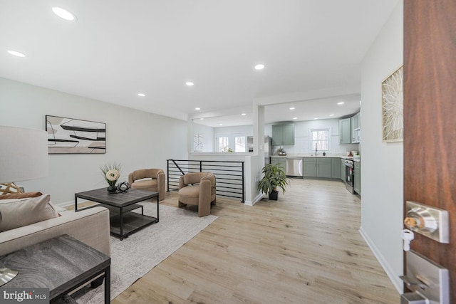 living area featuring baseboards, recessed lighting, and light wood-style floors