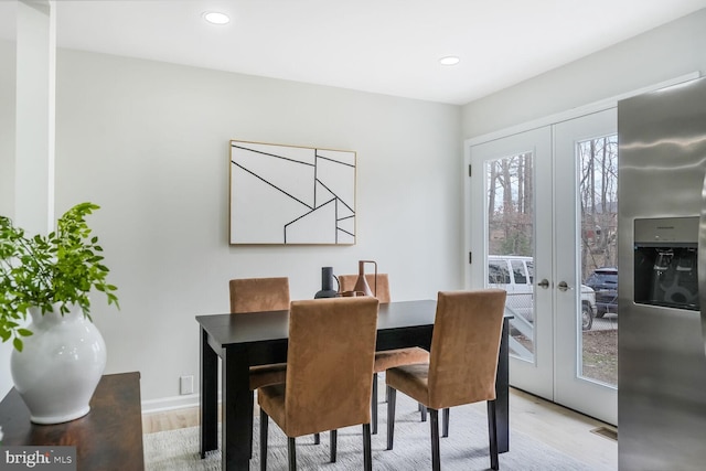 dining space with light wood finished floors, french doors, and recessed lighting