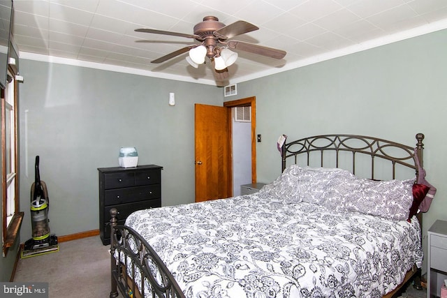 bedroom featuring ceiling fan, visible vents, baseboards, ornamental molding, and carpet