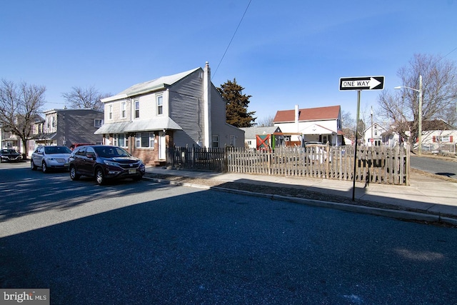 exterior space featuring a residential view and fence