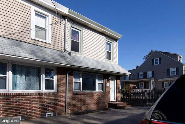 view of property with crawl space and brick siding