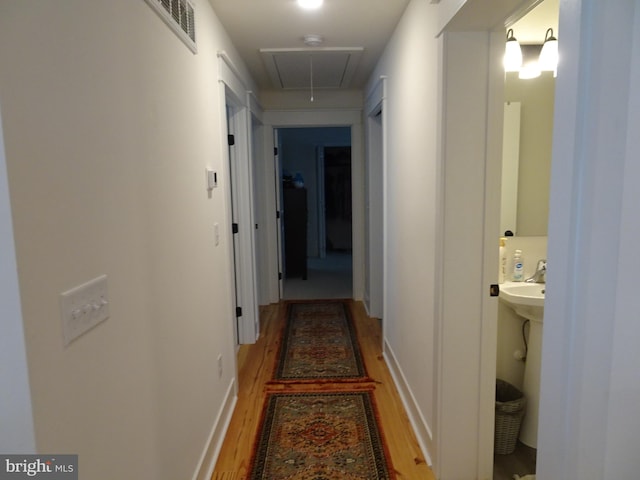 hallway with hardwood / wood-style floors