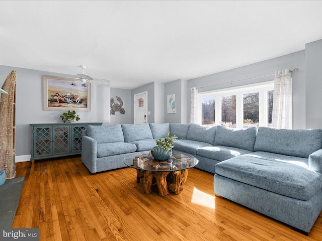 living room featuring wood-type flooring and ceiling fan