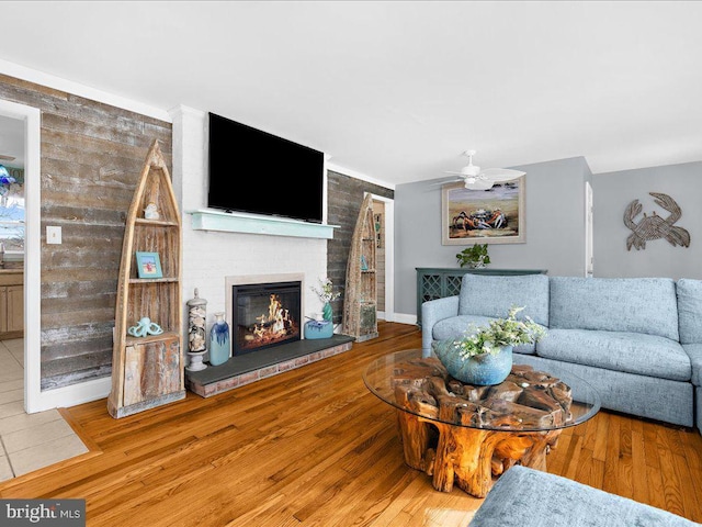 living room featuring hardwood / wood-style floors, a fireplace, and ceiling fan