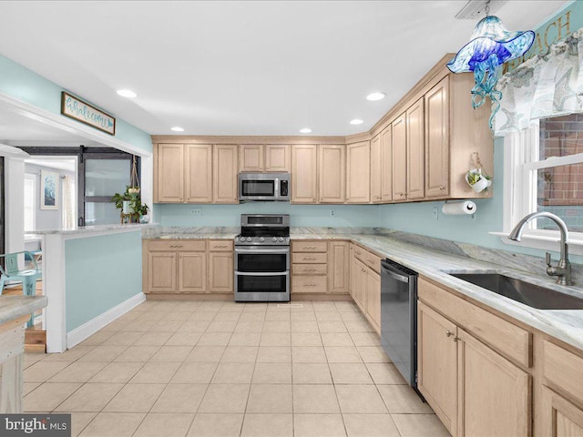 kitchen featuring stainless steel appliances, light tile patterned flooring, sink, and light brown cabinetry