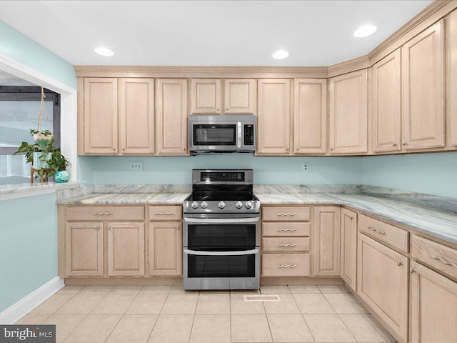 kitchen with appliances with stainless steel finishes, light tile patterned floors, and light brown cabinets