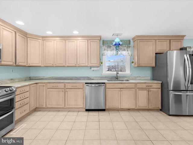 kitchen with appliances with stainless steel finishes, light brown cabinetry, and sink