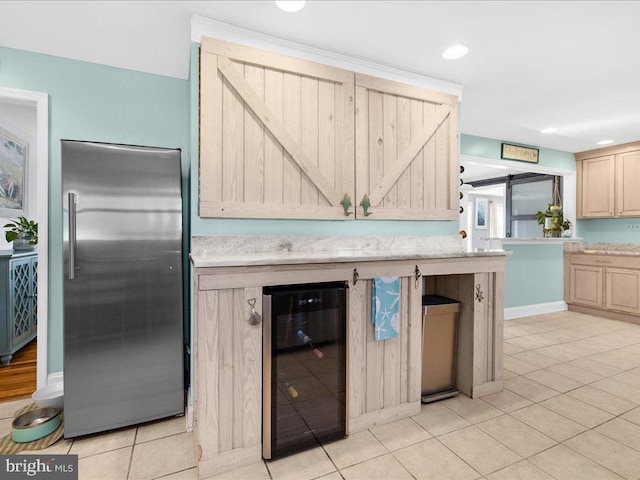 kitchen with wine cooler, high end refrigerator, light tile patterned floors, and light brown cabinets